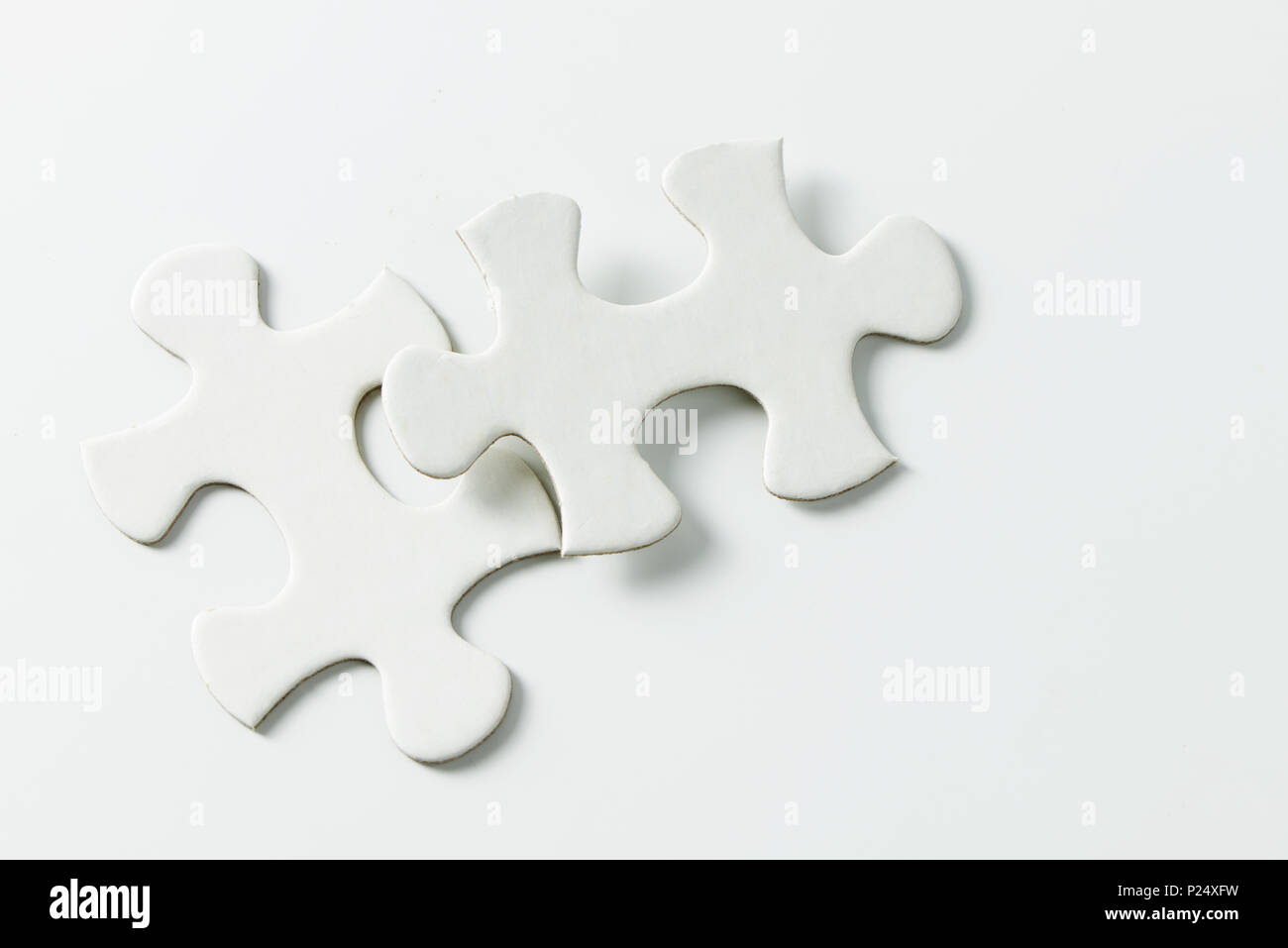 Two pieces of white jigsaw puzzle Stock Photo