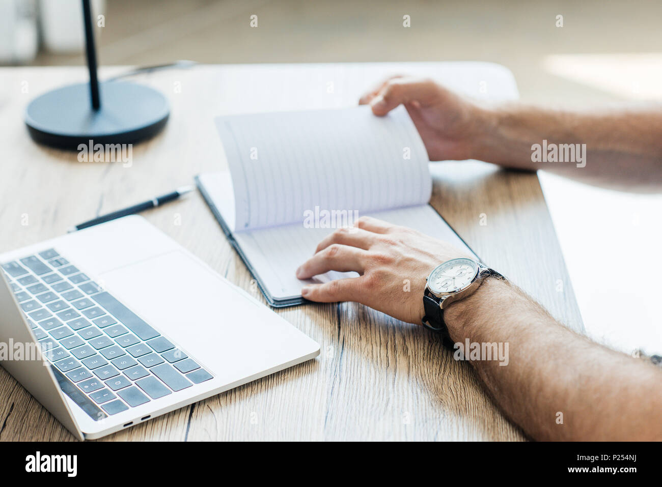 Person With Notebook close-up partial view of person holding blank notebook at workplace ...