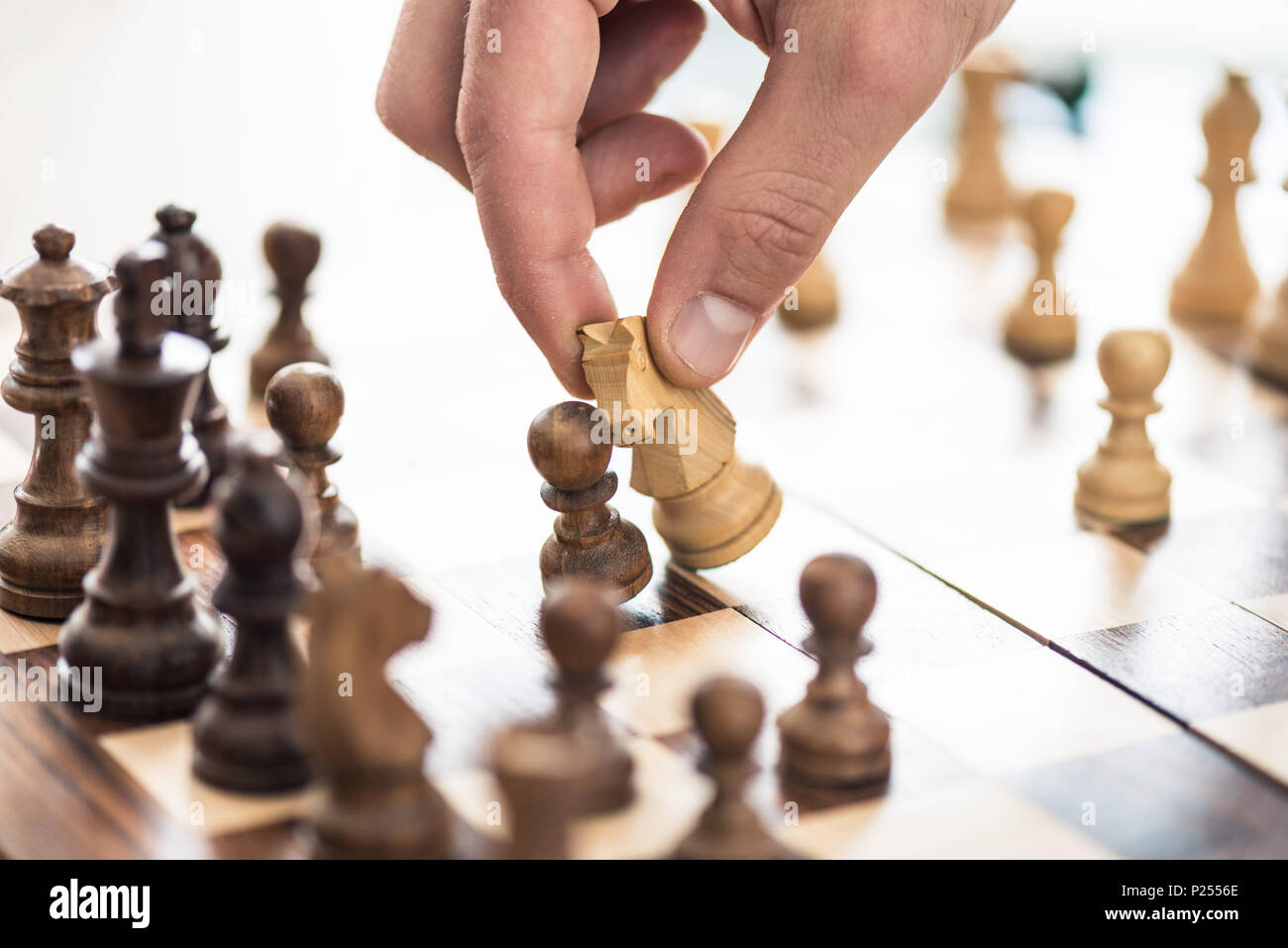 close-up partial view of human hand playing chess Stock Photo