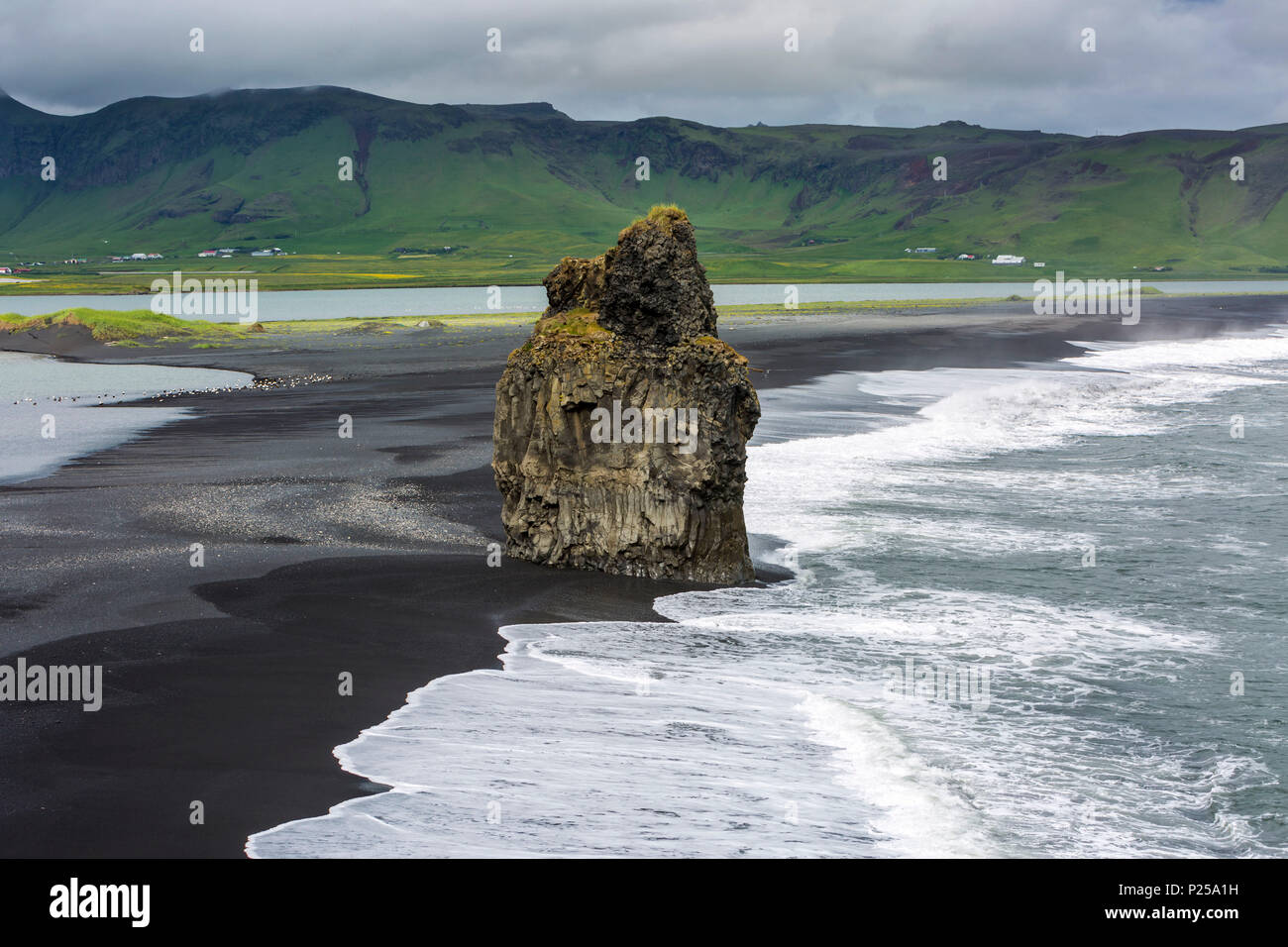 The Black Beach near Vik, Iceland, Arnardrangur or 'Eagle Rock', eagles nested there until 1850, Reynisfjara black sand beach created by lava flowing into the ocean, wettest place in Iceland Stock Photo