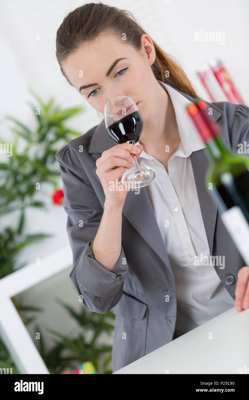 beautiful young woman tasting wine in a restaurant and smiling Stock Photo
