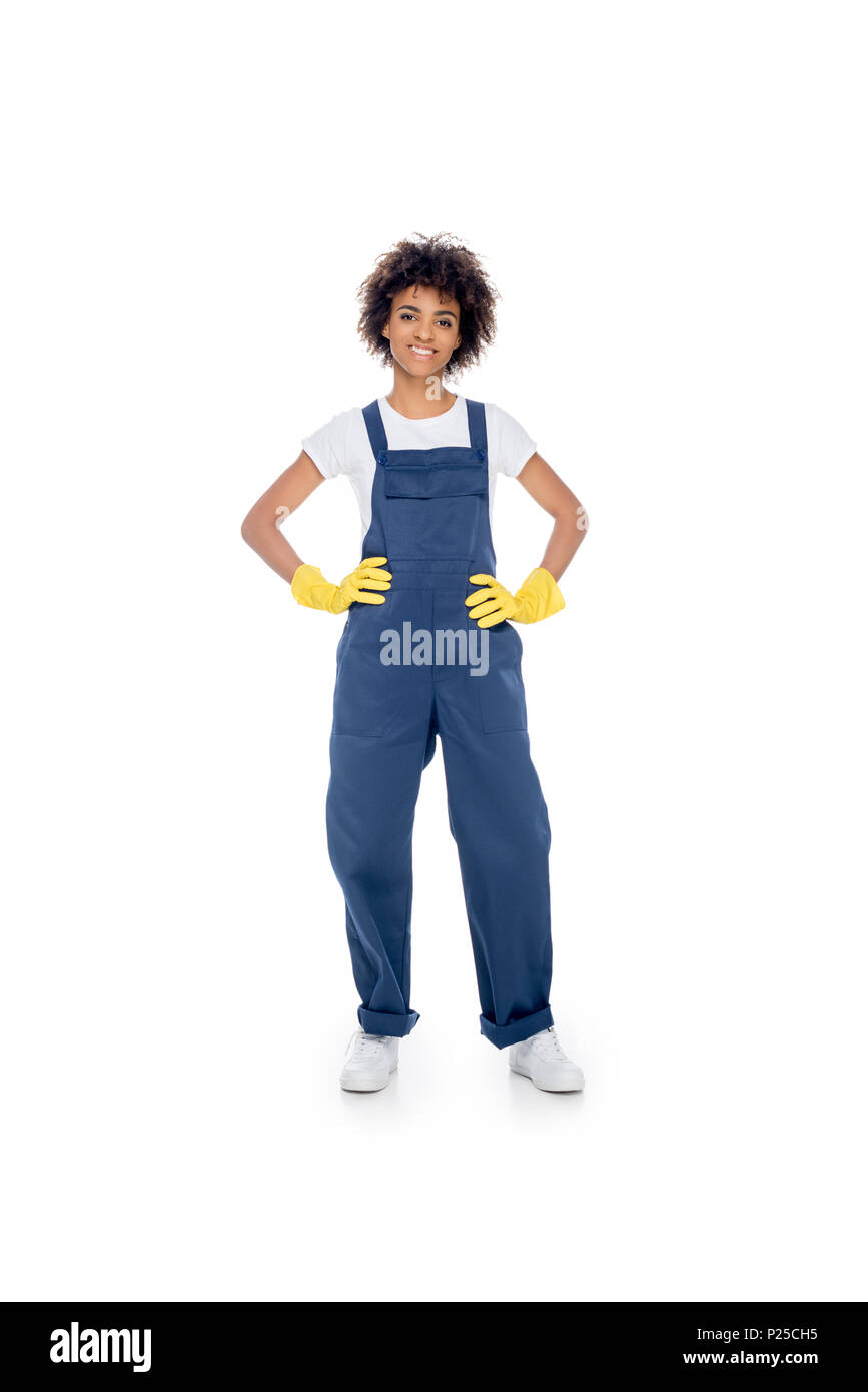 smiling african american female cleaner in uniform standing akimbo isolated on white Stock Photo