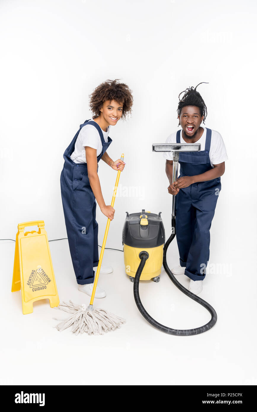 african american cleaners in uniform with cleaning supplies looking at  camera isolated on white Stock Photo - Alamy