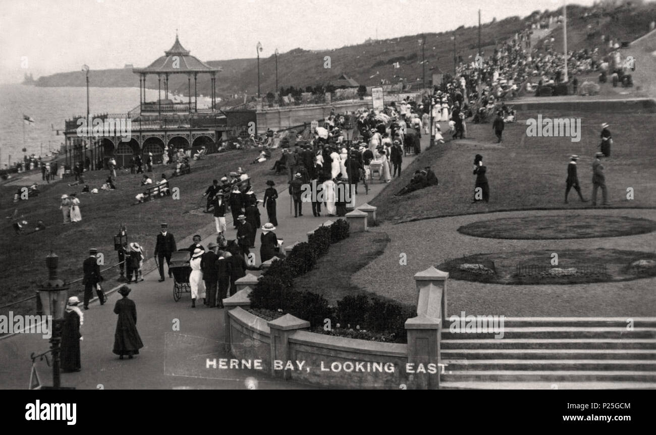 . English: A photograph by Frederick Christian Palmer (d.1941), of the promenade passing Kings Hall (built 1904), at Herne Bay, Kent, England, in the pre-First World War years of the 20th century. Fred C. Palmer worked at Herne Bay from 1903 to 1920, principally from his Tower Studio. The bandstand (seen on the upper part of the hall), does not exist today, although the upper enclosure railings do. To the right of the bandstand is a tiered platform for audience seating. The columned stone wall and steps edging the gardens have been replaced by bollards of cast iron and wood. The path below the Stock Photo