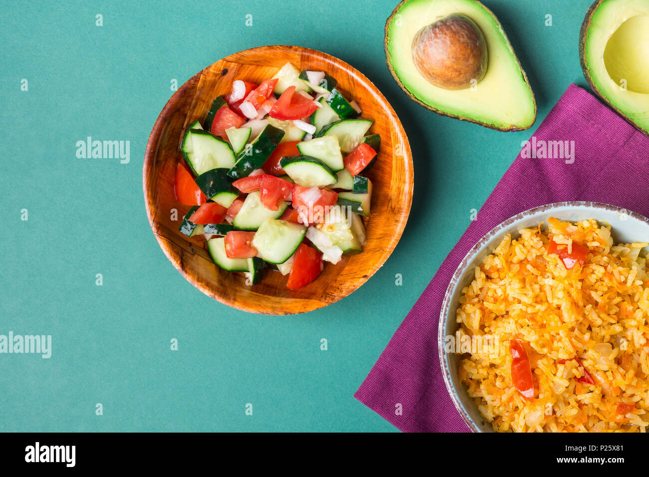 Traditional National Mexican Tomato Rice Stewed Pilaf with Hot Chili Peppers Garlic in Turquoise Bowl. Fresh Cucumber Onion Salsa Salad Avocado for Gu Stock Photo