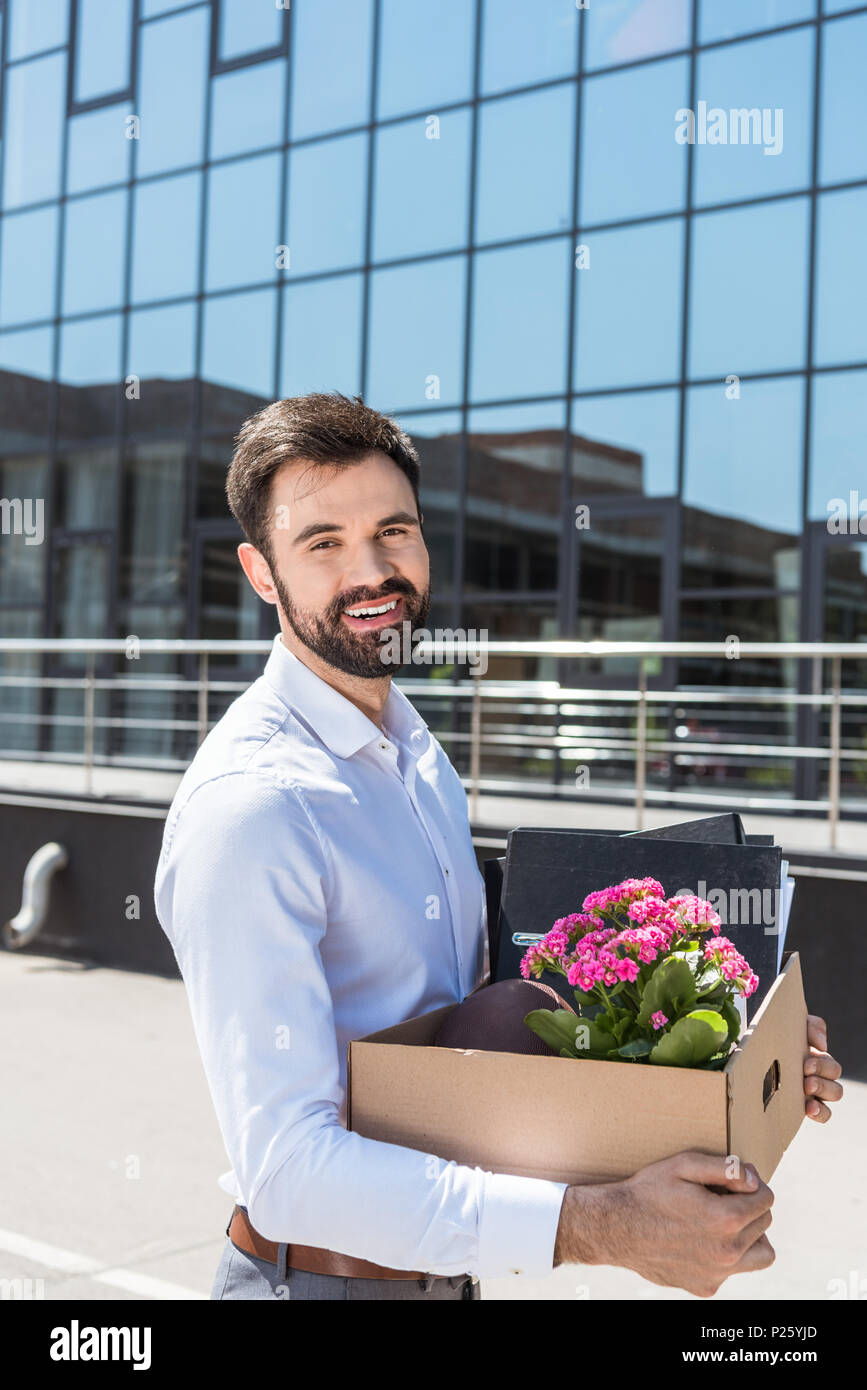 happy young manager with box of personal stuff after he was fired Stock Photo