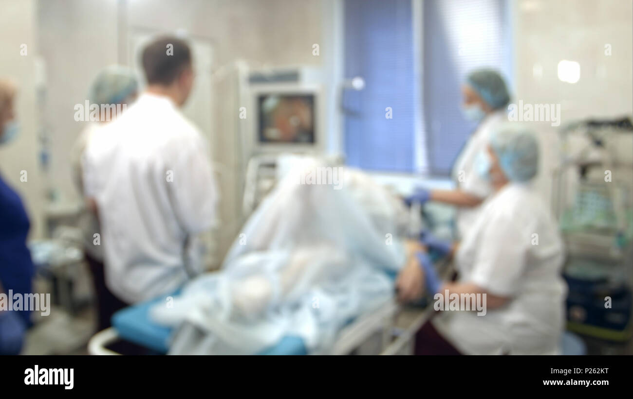 Doctors and nurses performing endoscopic procedure in hospital Stock