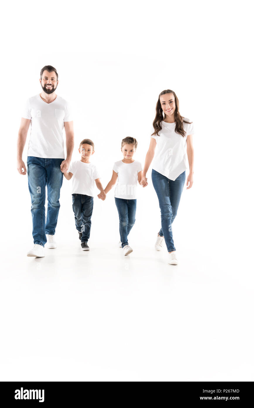 smiling family holding hands while walking together isolated on white Stock Photo
