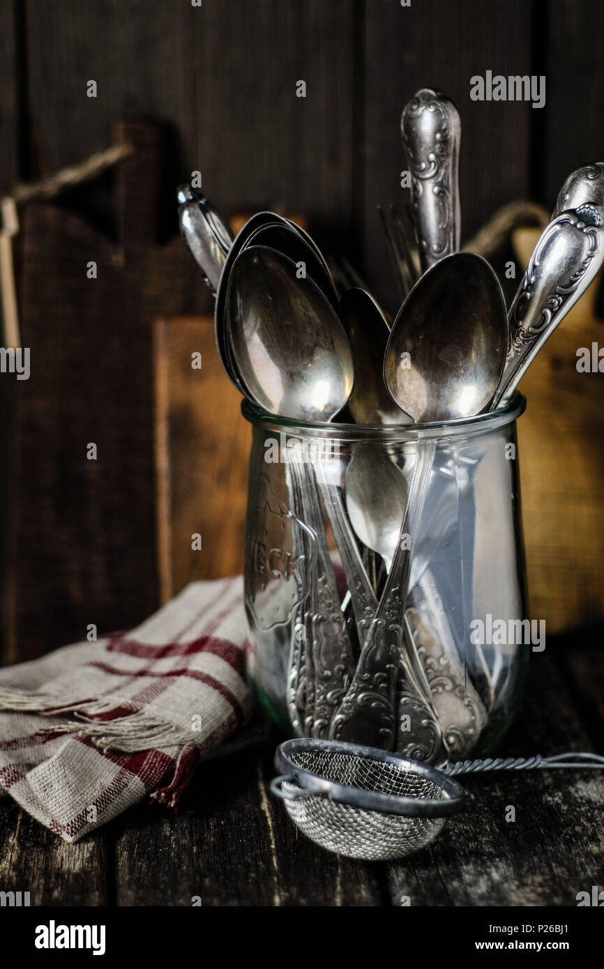 https://c8.alamy.com/comp/P26BJ1/still-life-with-vintage-kitchen-utensils-old-silver-cutlery-in-a-wake-up-glass-old-sieve-linen-and-wooden-boards-P26BJ1.jpg