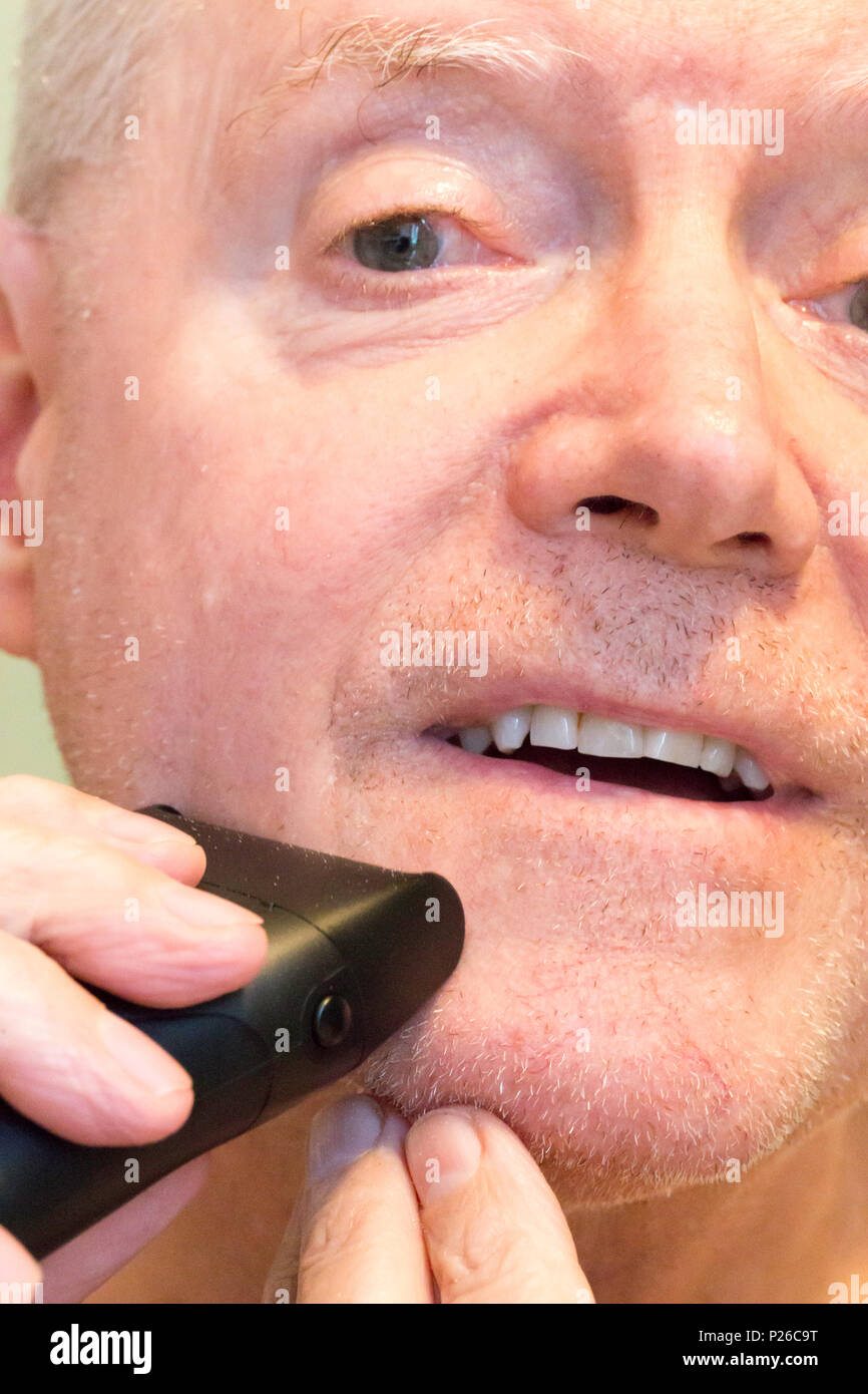 Senior Man Shaving with an Electric Shaver, USA Stock Photo