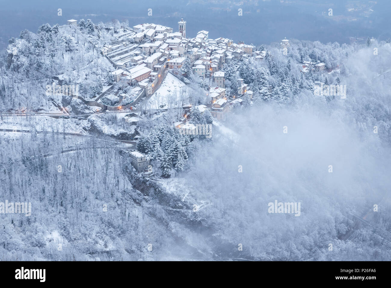 Evening view of the town of Santa Maria del Monte after a snowfall in winter from the Campo dei Fiori. Campo dei Fiori, Varese, Parco Campo dei Fiori, Lombardy, Italy. Stock Photo