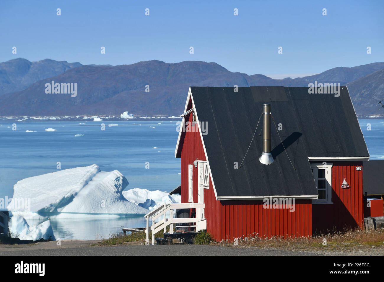Nordic colored house with Iceberg, Narsaq, Greenland Stock Photo