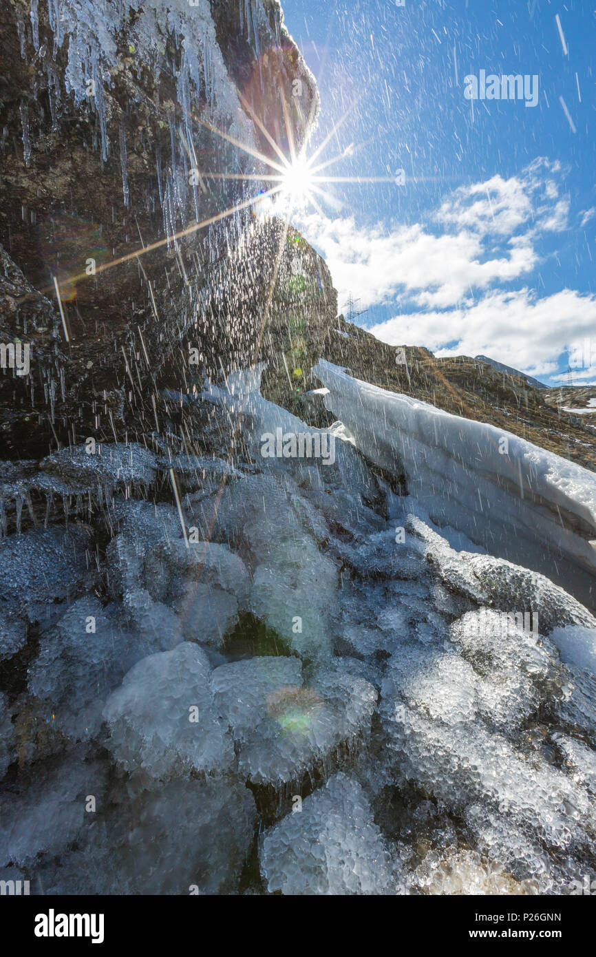 Sunburst on the melting ice on rocks, Bernina Pass, canton of Graubunden, Engadine, Switzerland Stock Photo