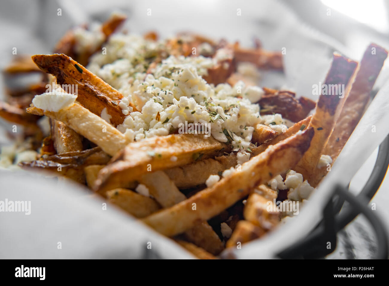 Delicious Mediterranean street cart fried potatoes with feta cheese herbs and spices Stock Photo