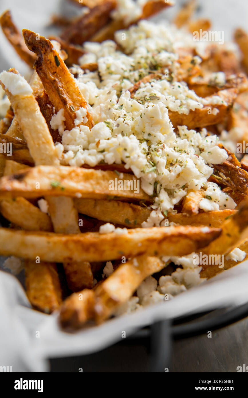 Delicious Mediterranean street cart fried potatoes with feta cheese herbs and spices Stock Photo