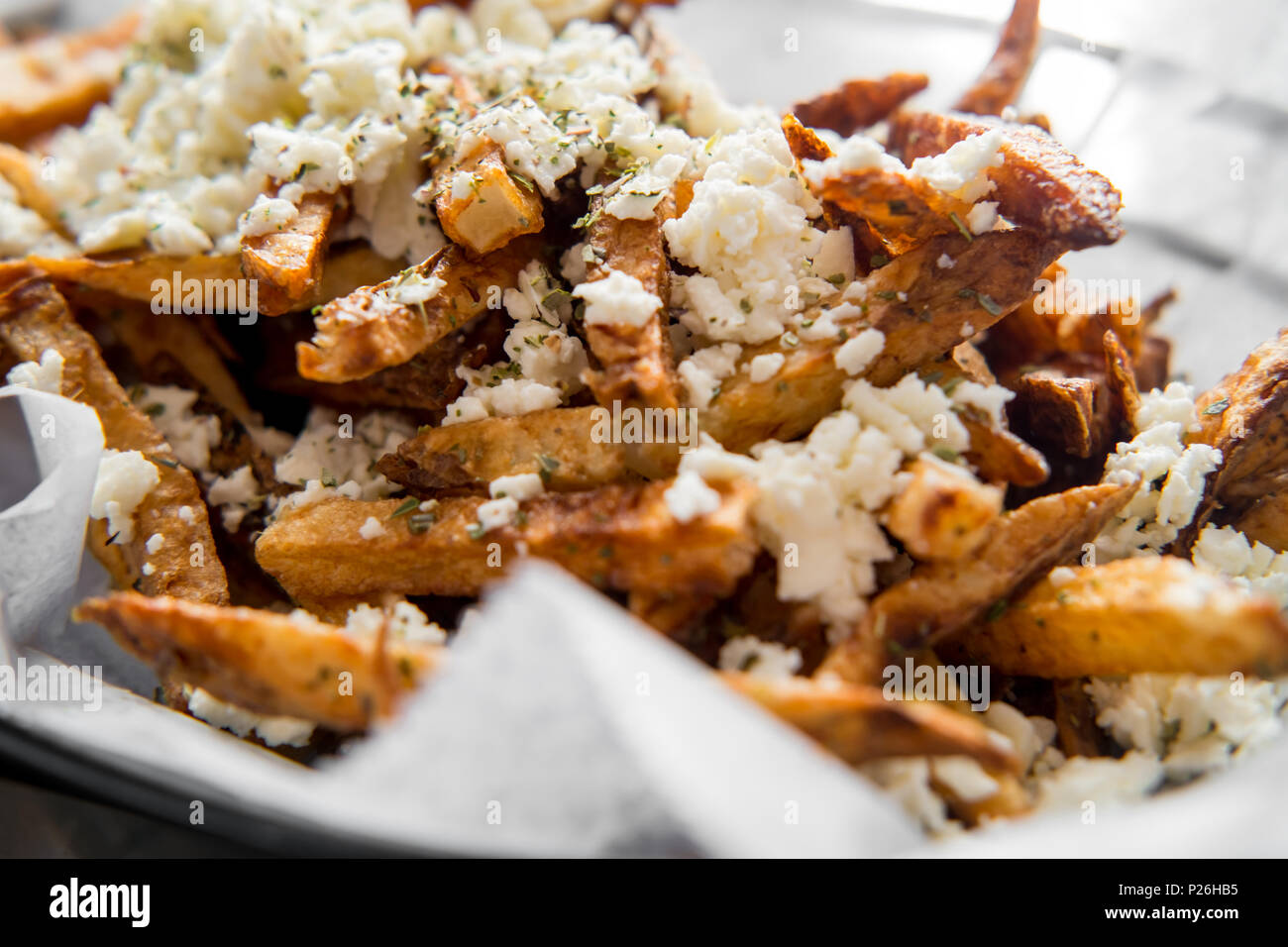 Delicious Mediterranean street cart fried potatoes with feta cheese herbs and spices Stock Photo