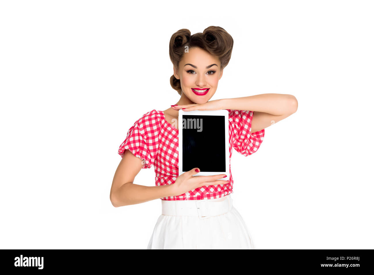 portrait of smiling woman in pin up style clothing showing tablet ...