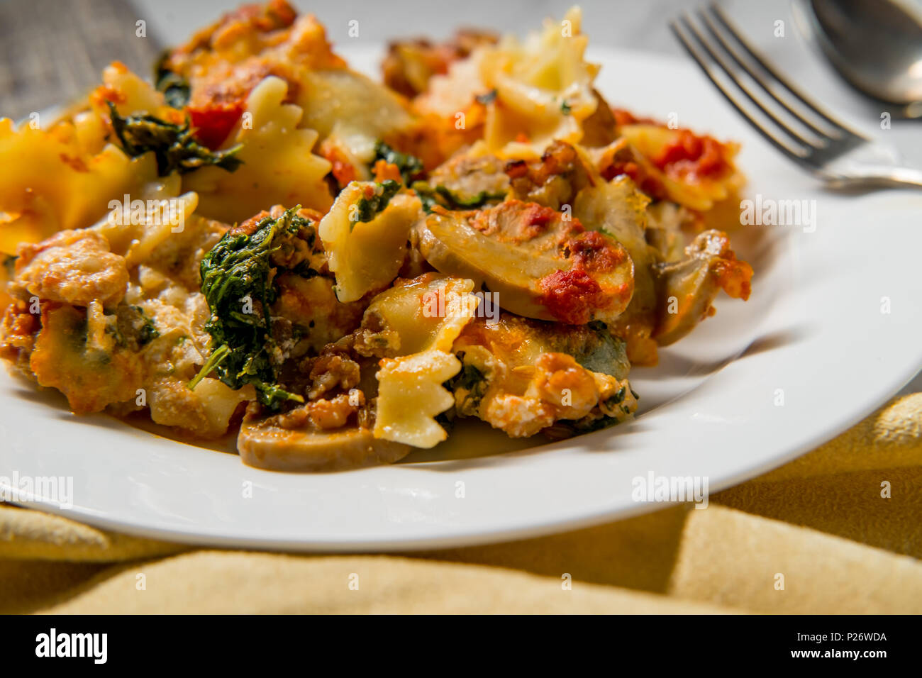 Bowtie pasta lasagna with marinara sauce sausage mushrooms and spinach