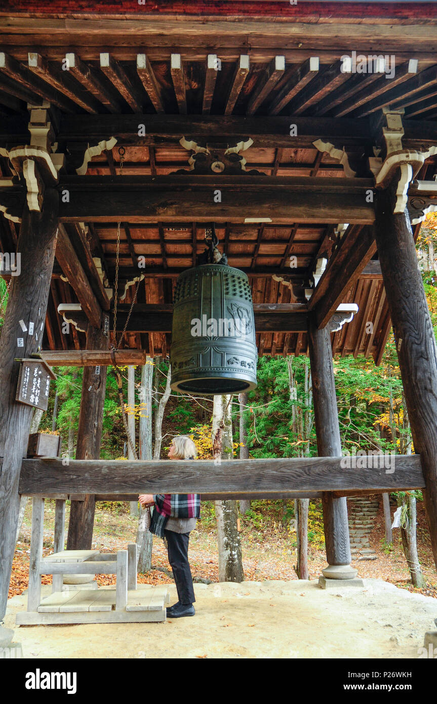 A female foreign tourist exploring the belltower of a Shinto shrine at Hida-no-Sato folk village, Takayama, Japan Stock Photo