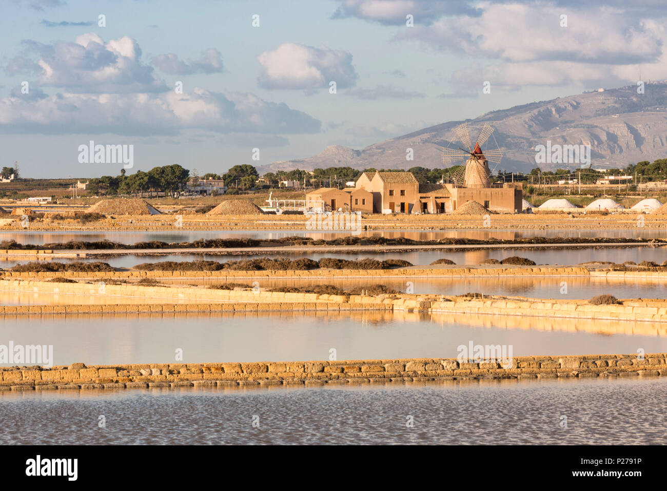 Salt pans in front of Infersa windmill on the coast connecting Marsala to Trapani, Trapani province, Sicily, Italy Stock Photo