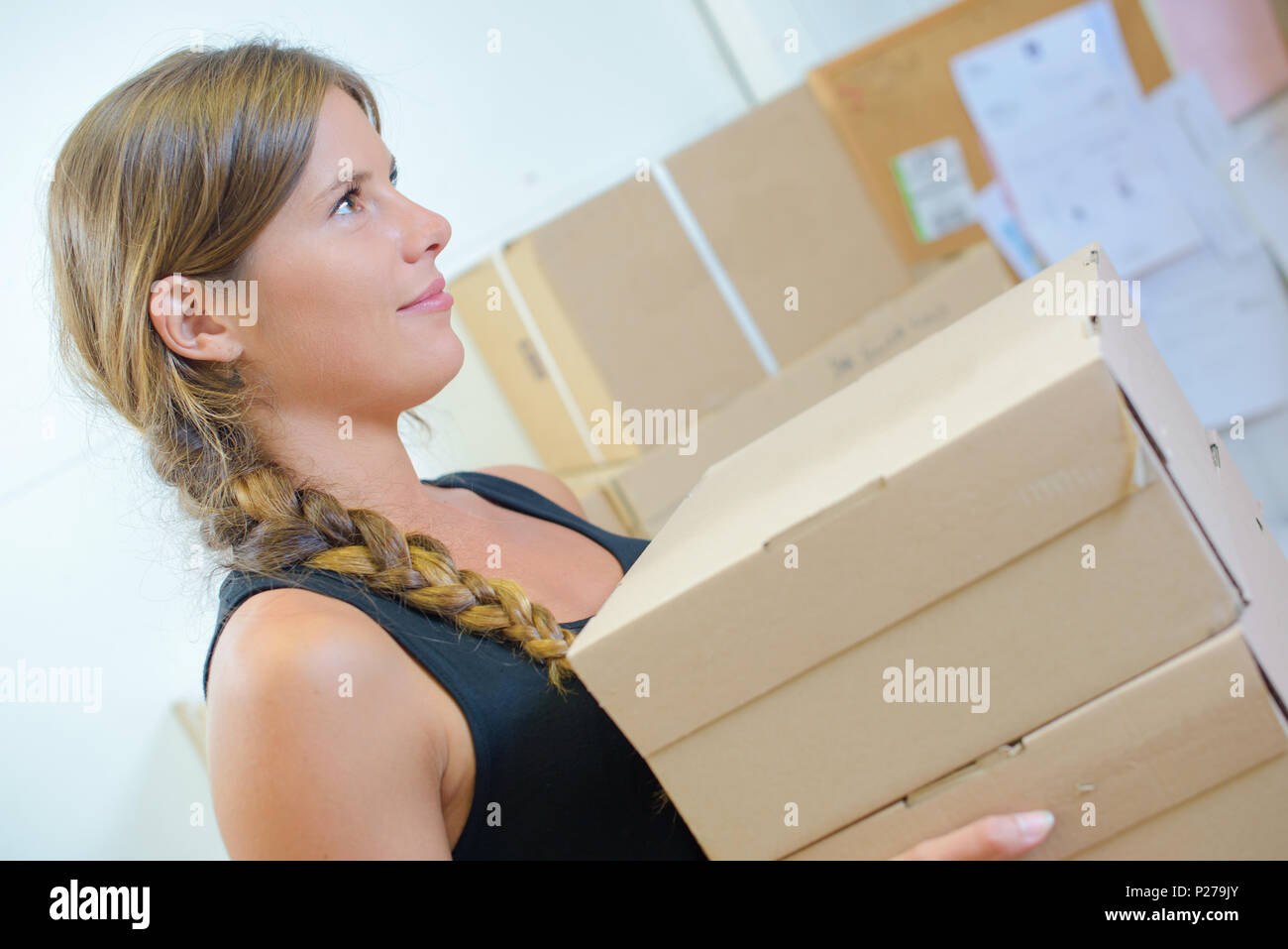 Lady carrying stack of boxes Stock Photo - Alamy