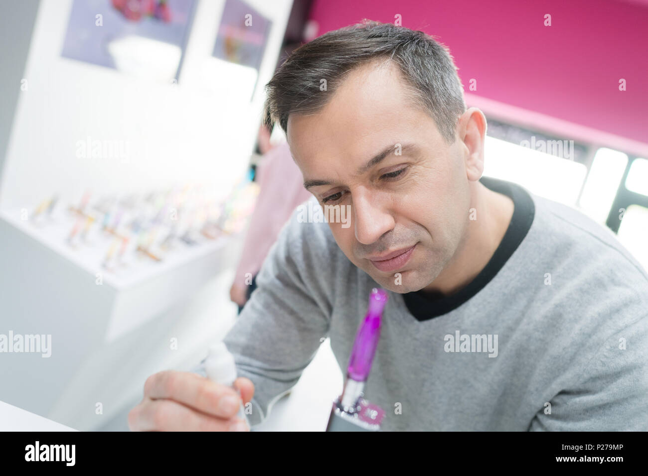 man setting electronic cigarette for a client Stock Photo