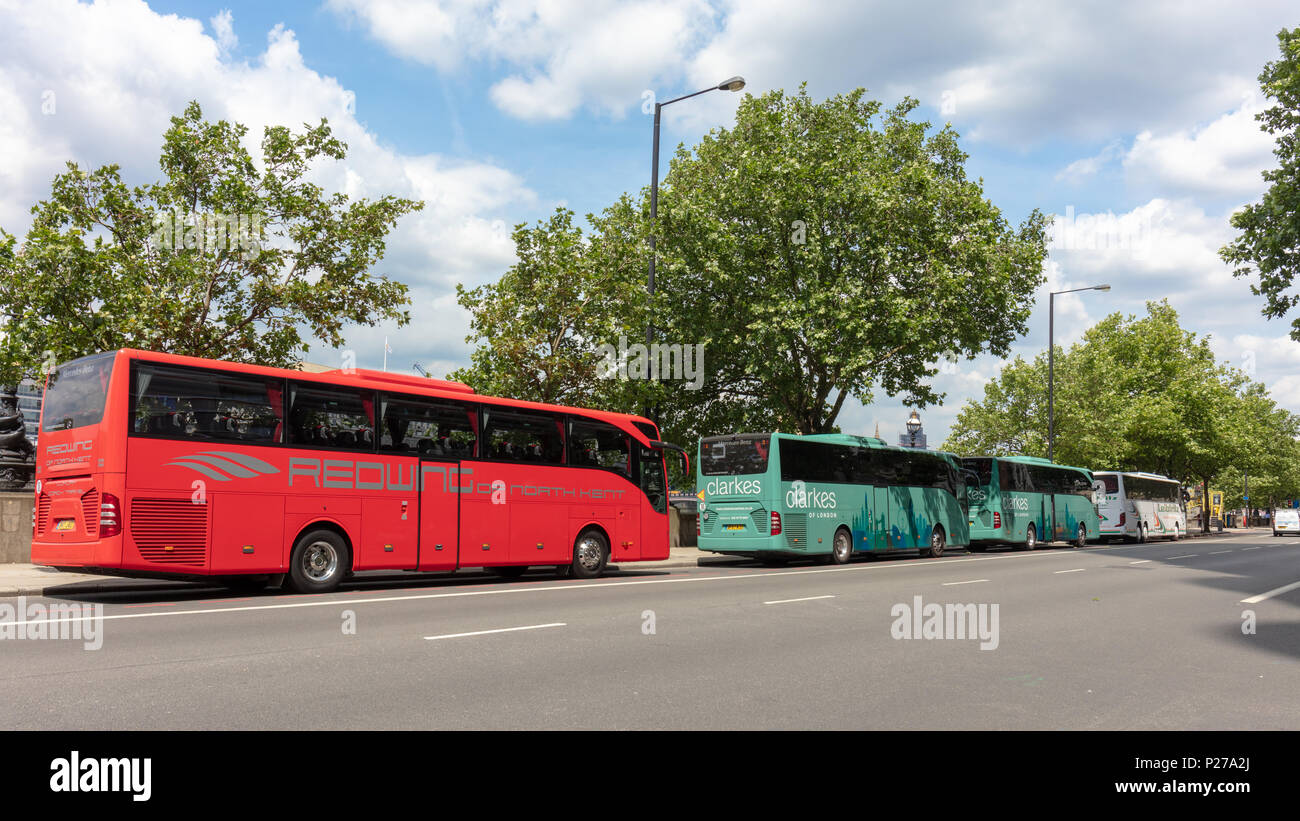 London, UK; 13th June 2018; Row of Brightly Coloured Coaches Parked By the Side of the Road on albert Embankment in Central London Stock Photo