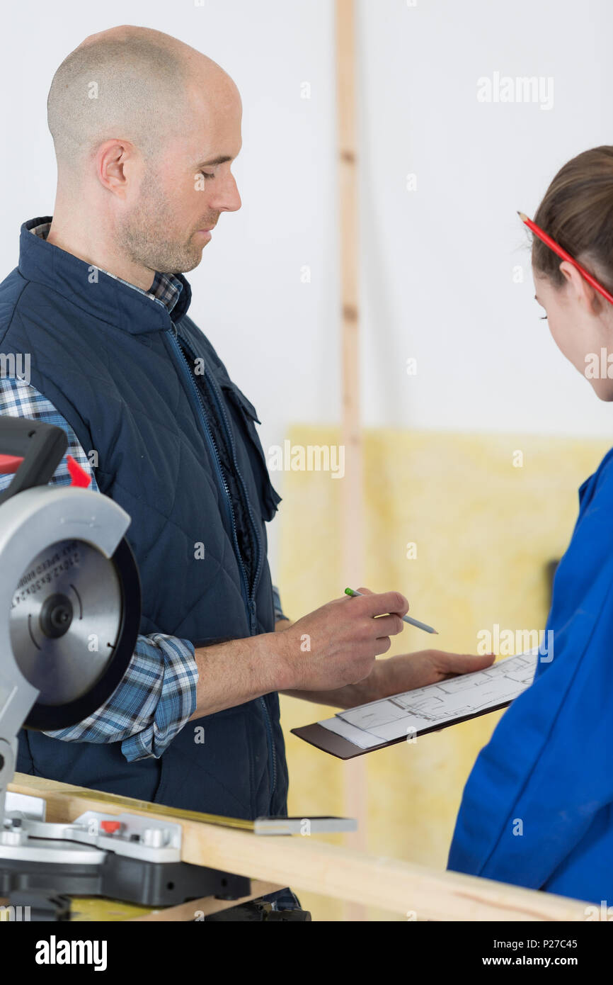 student and teacher in carpentry class using circular saw Stock Photo