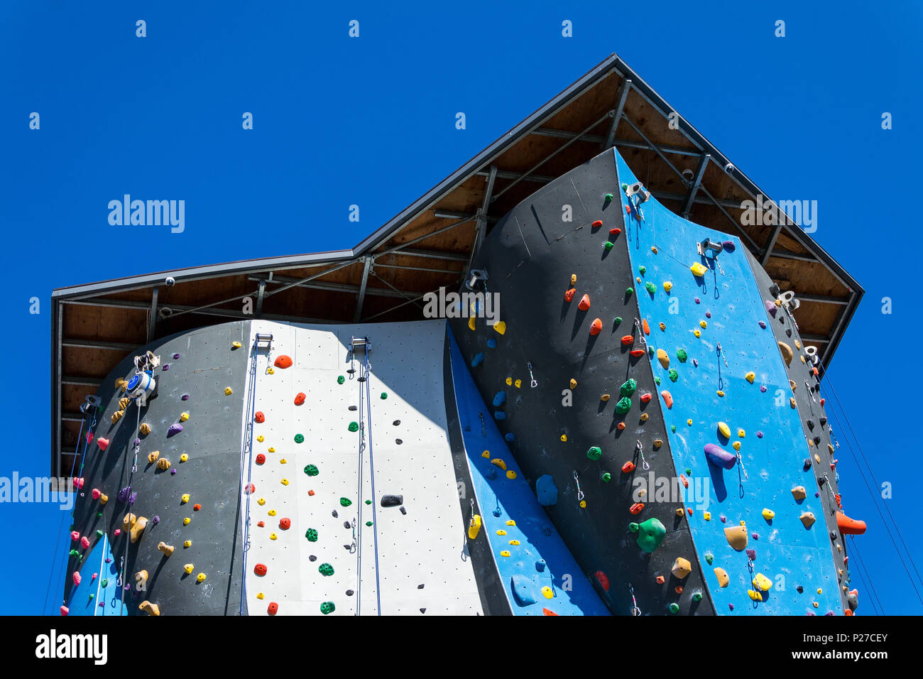 Roofed blue and black artificial rock climbing wall Stock Photo