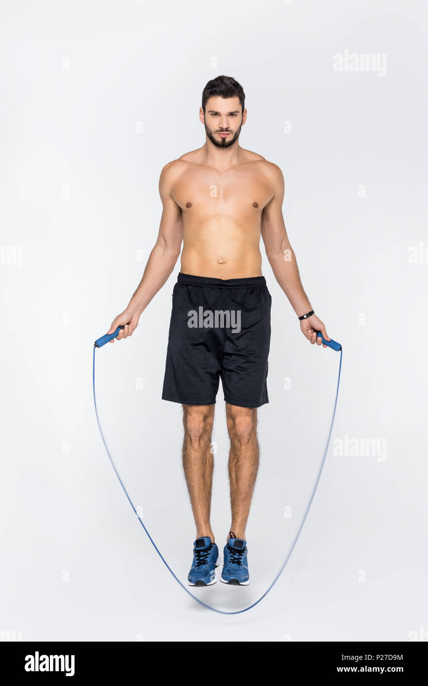 young shirtless sportsman jumping over rope isolated on white Stock ...