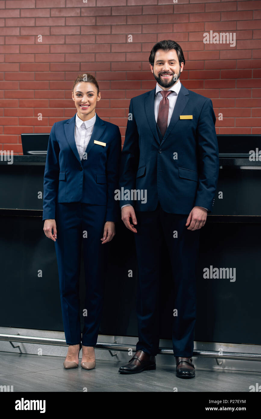 Happy Hotel Receptionists Standing Together In Front Of Counter