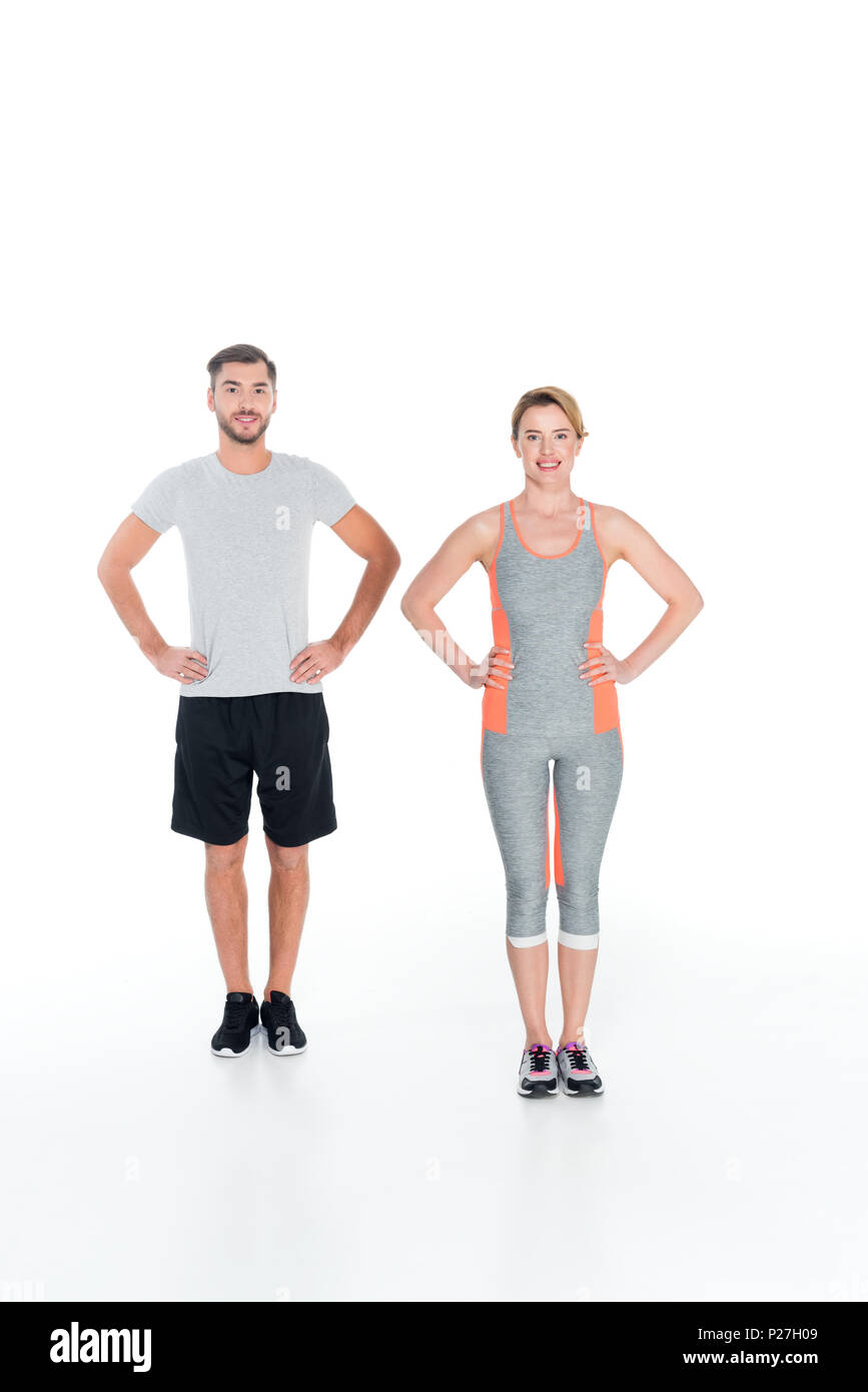 smiling couple in sportswear standing akimbo isolated on white Stock Photo