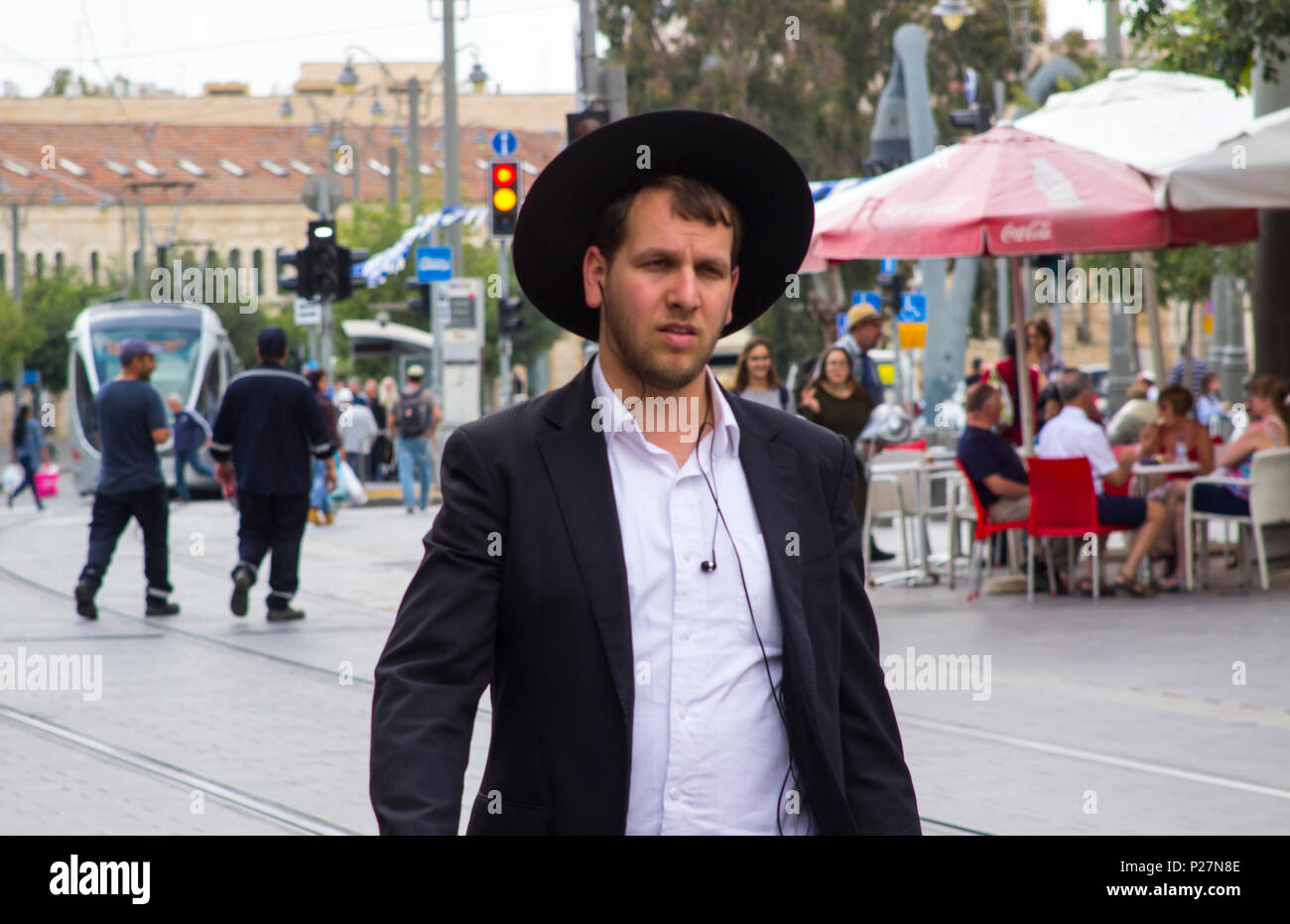 9 May 2018 A young clean shaven Orthodox Hasidic Jew in traditional clothing on foot in a busy street in Jerusalem Israel Stock Photo