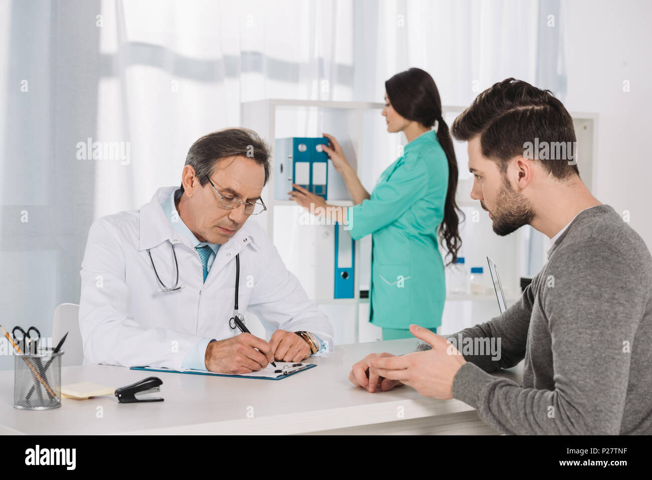 Врач говорит с пациентом. Консультация врача онколога. Опытный врач. Мужчина разговаривает с доктором. Консультация уролога.