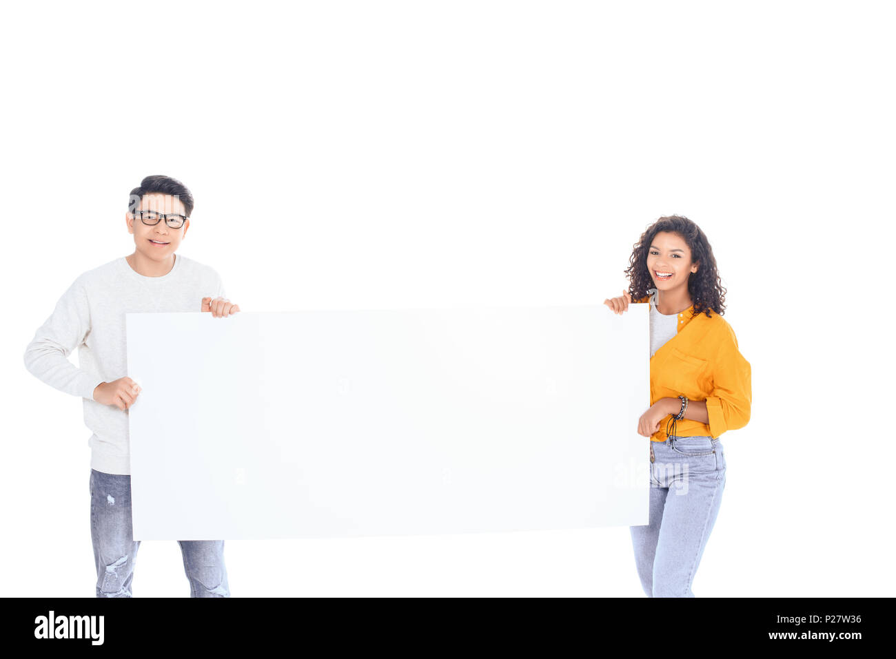 portrait of multicultural teenagers holding blank banner in hands isolated on white Stock Photo