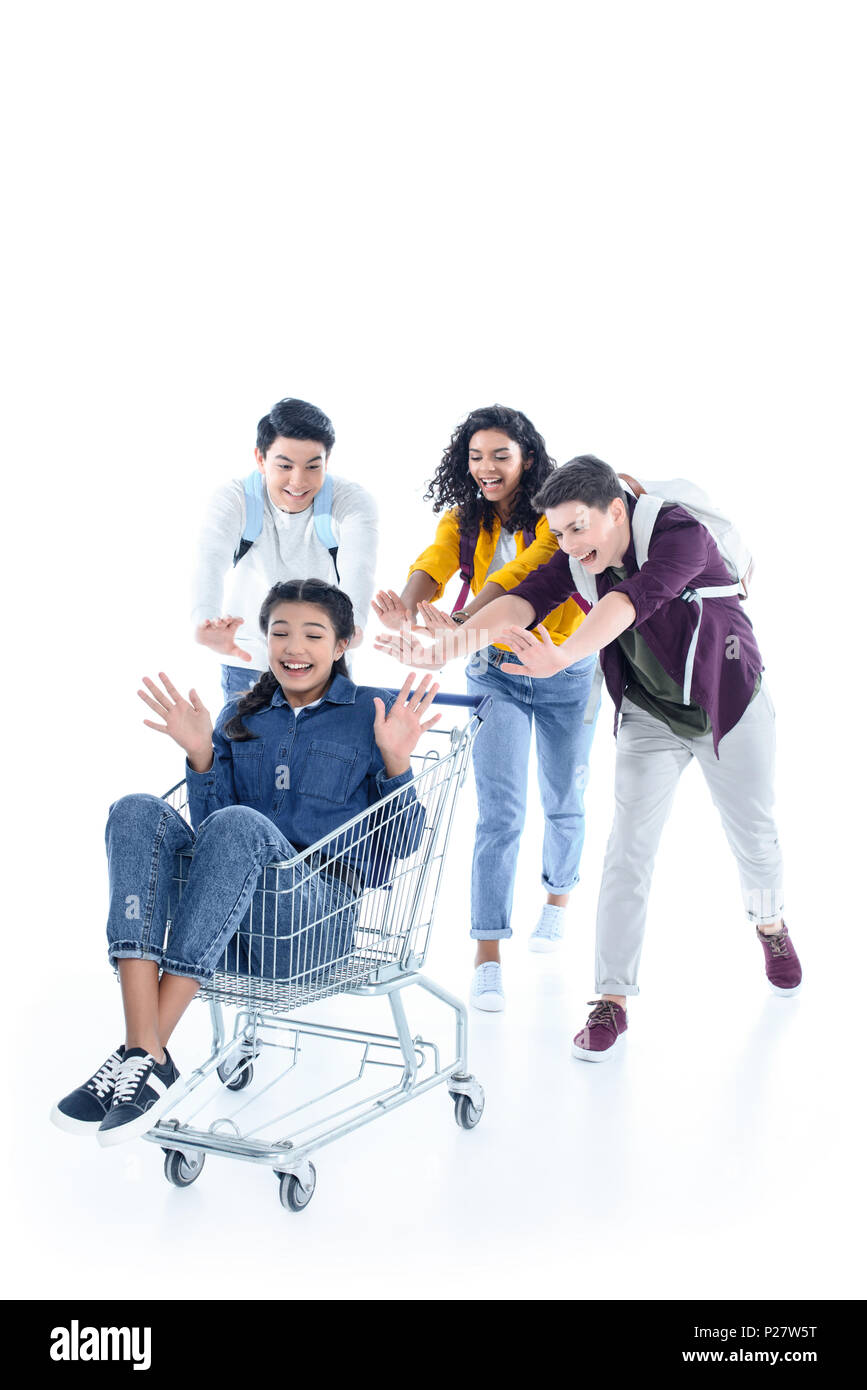 group of teen students riding their friend on shopping cart isolated on