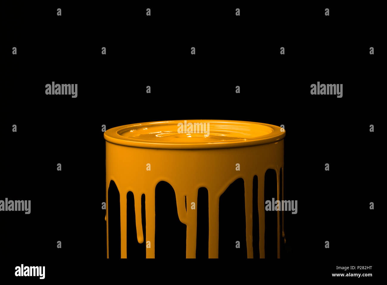 Colorful paint leaking down over the part of metal bucket. Isolated over black background Stock Photo