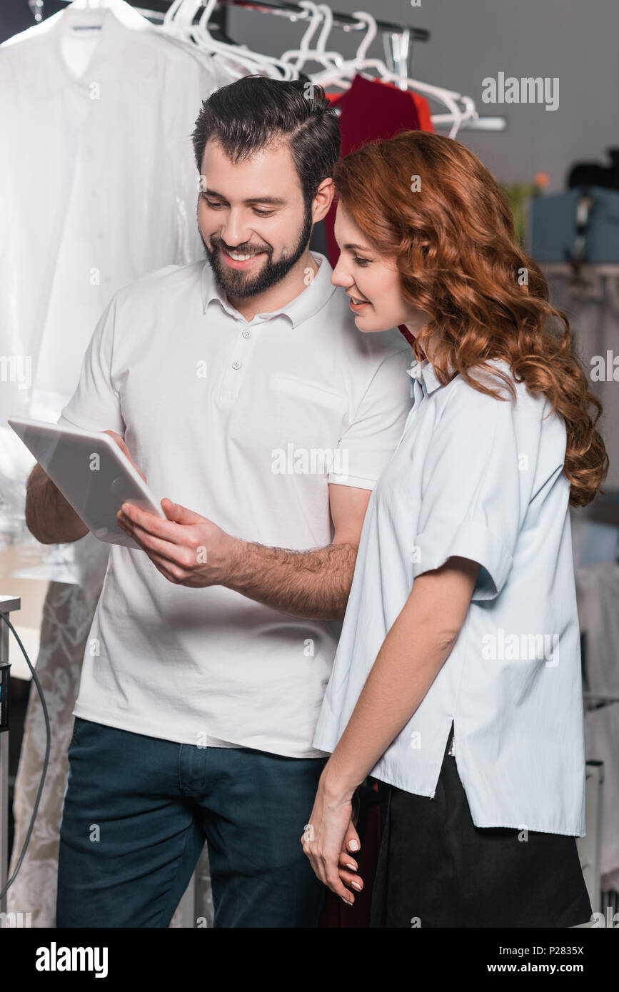 dry cleaning workers using tablet together at warehouse Stock Photo
