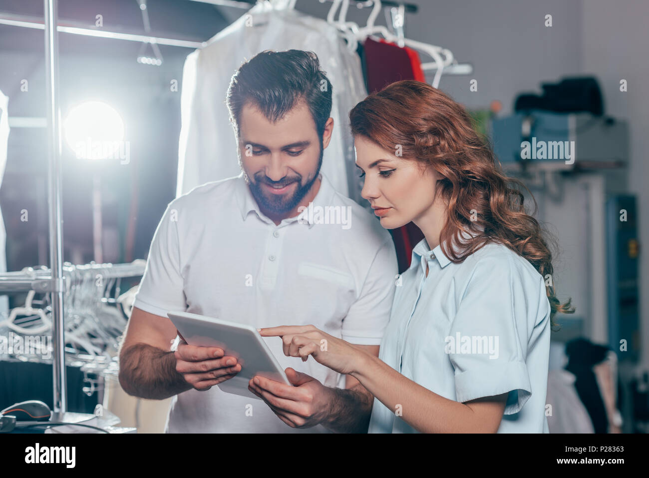 happy young dry cleaning workers using tablet together Stock Photo