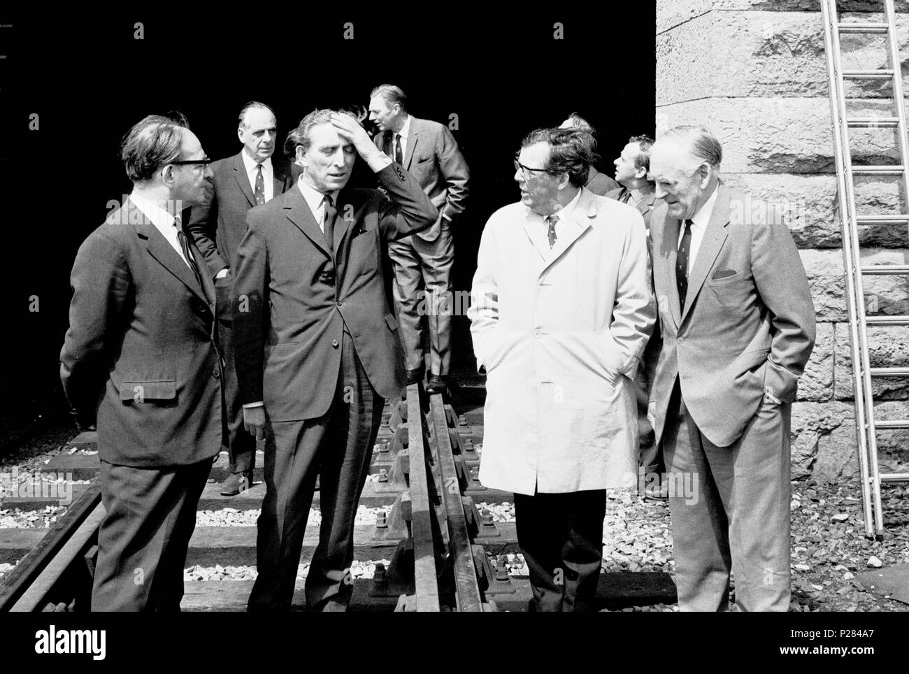 George Thomas, Secretary for Wales, puts his hand to his face while inspecting the fire-damaged tubular Britannia Bridge over the Menai Straight. Alongside Mr Thomas are (l-r) Fred Mulley, Minister of Transport, Cledwyn Hughes, Minister of agriculture, and Sir Henry Johnson, Chairman of the Railway Board. Stock Photo
