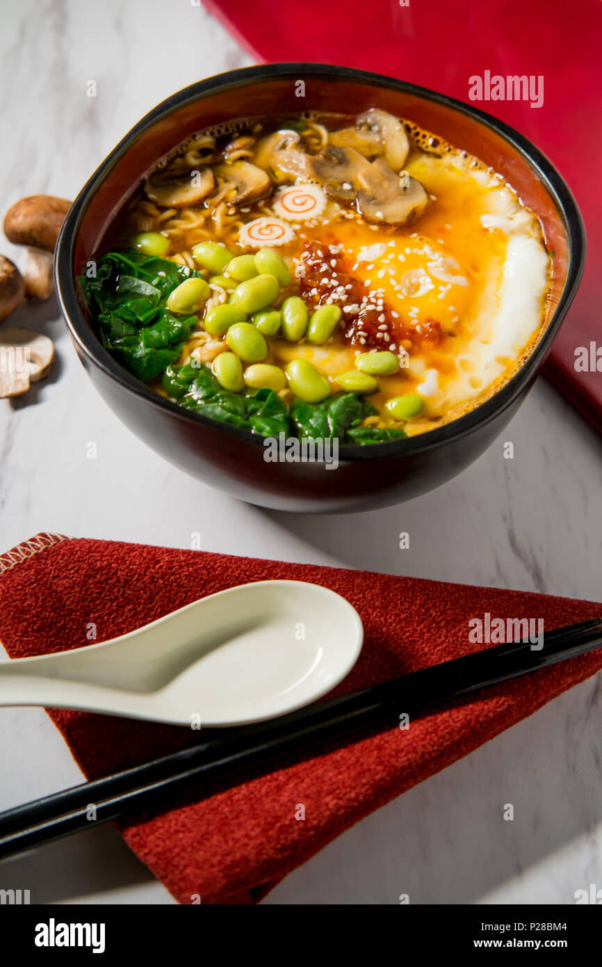 Spicy edamame and narutomaki spiral ramen noodle soup with runny fried
