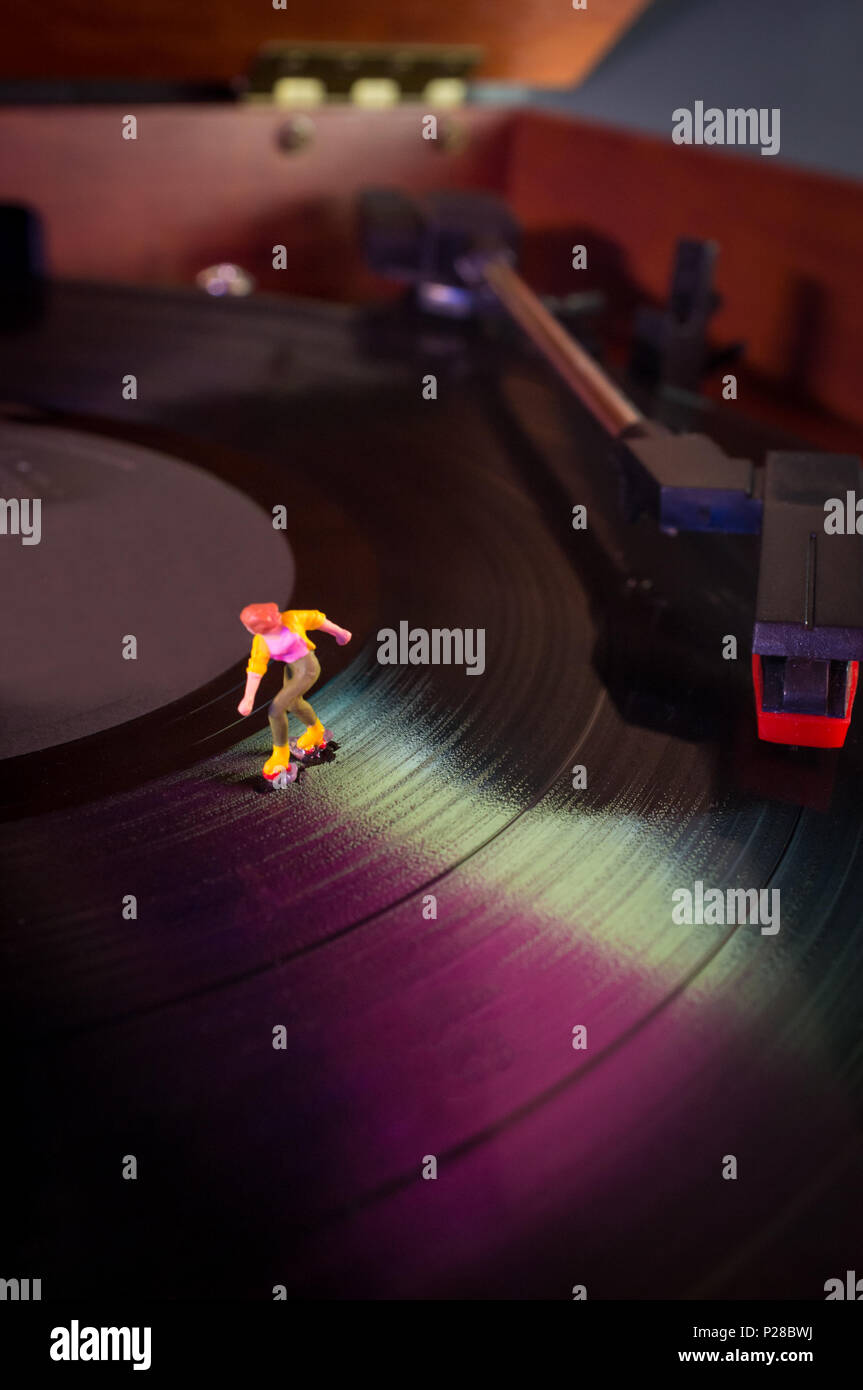 Miniature roller skating figures on vintage vinyl record in macro
