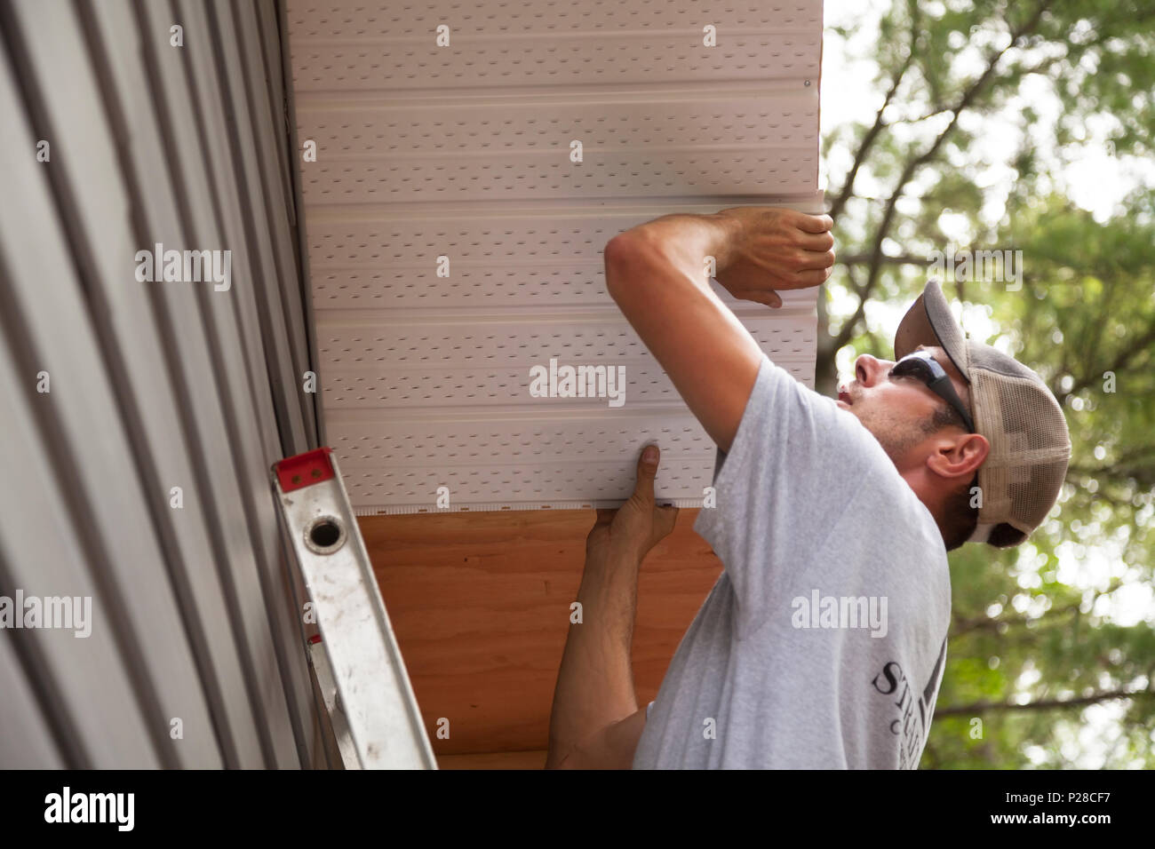 A worker installing soffits. Stock Photo