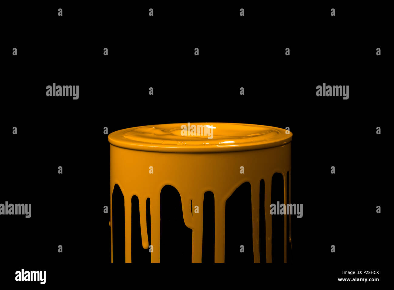 Colorful paint leaking down on wall of metal bucket. Isolated over black background Stock Photo