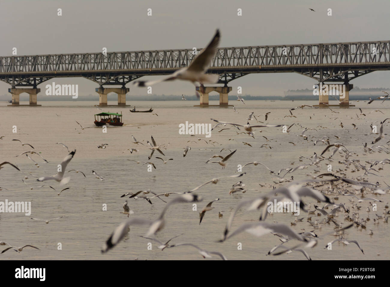 Mawlamyine (Mawlamyaing, Moulmein), Thanlwin Bridge, Thanlwin (Salween) River, road and railway bridge, fishing boat, people feed gulls, Mon State, Myanmar (Burma) Stock Photo
