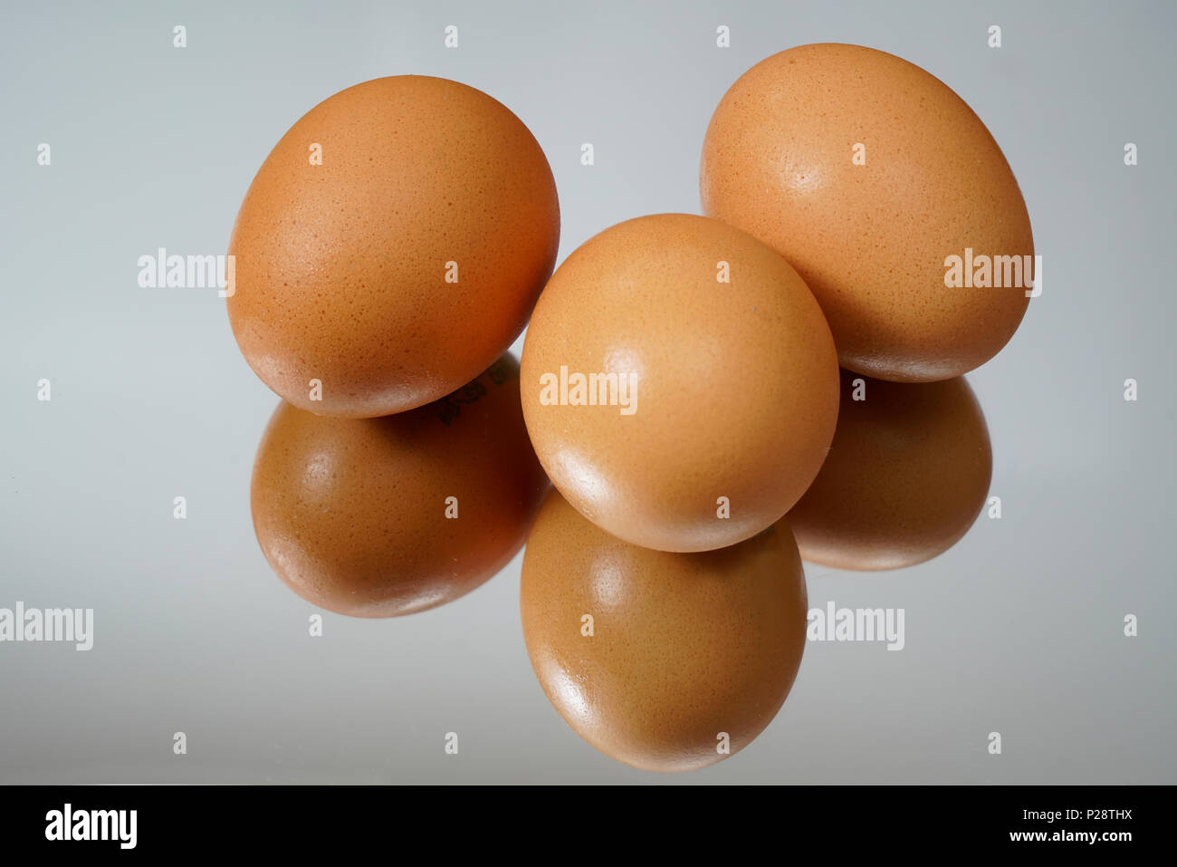 three eggs on a mirror Stock Photo Alamy