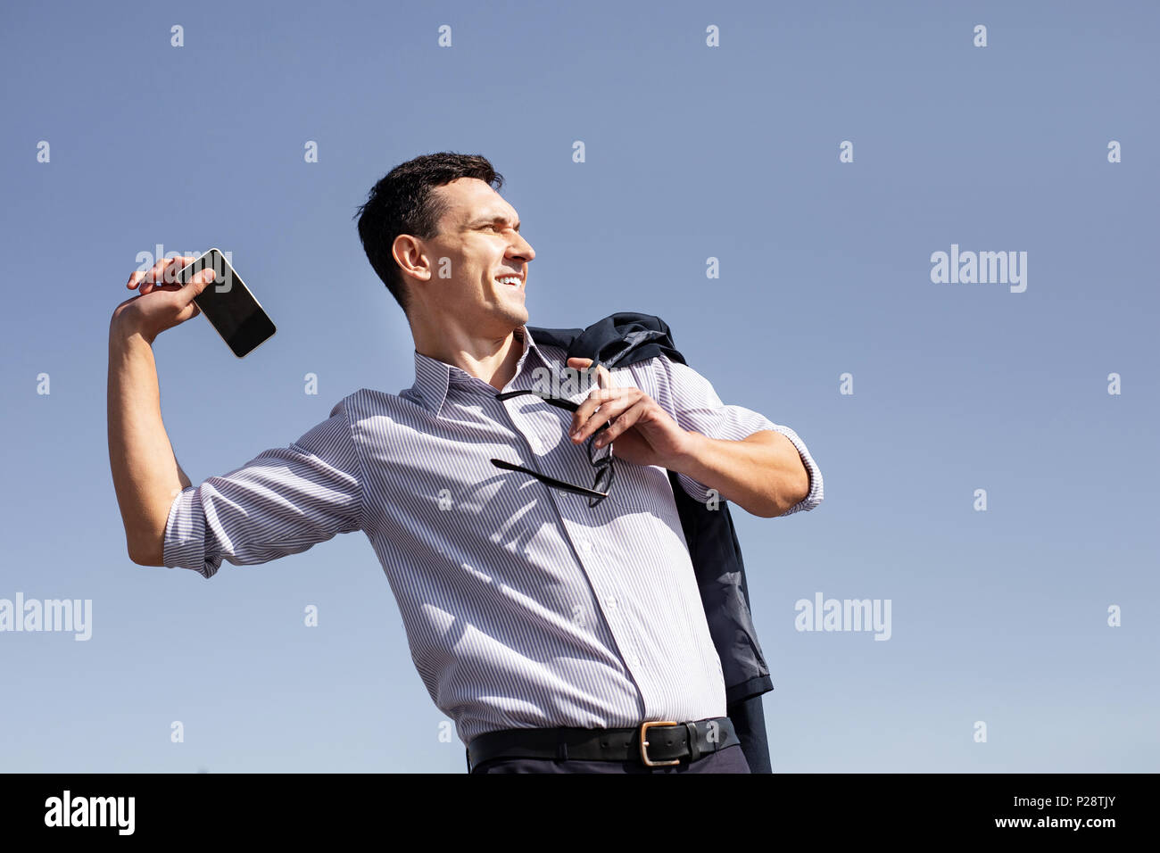 Business man feeling angry while throwing his phone away Stock Photo