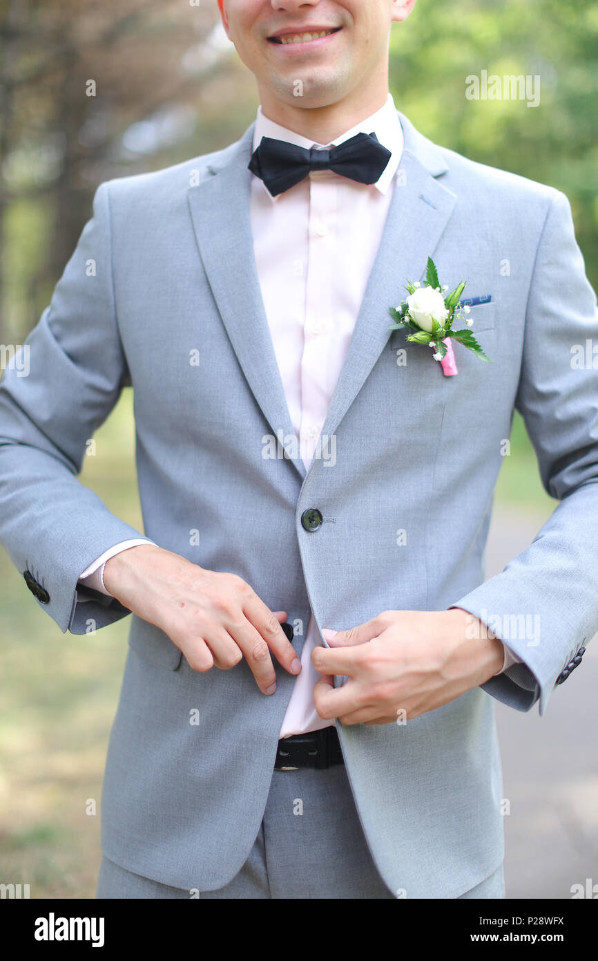 Young smiling groom wearing grey suit Stock Photo - Alamy