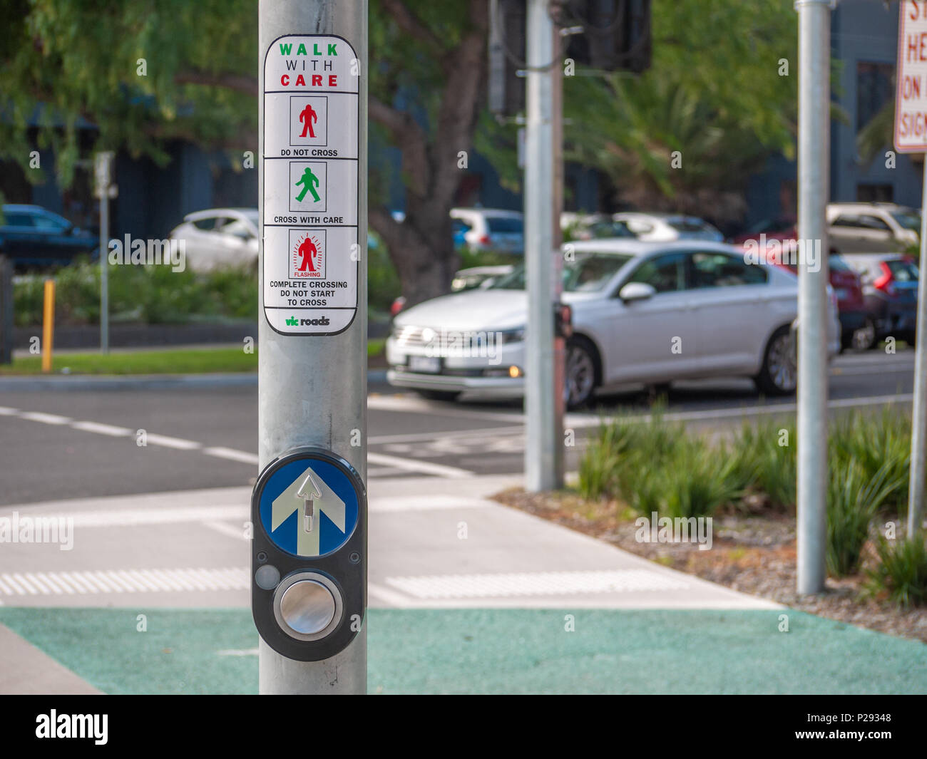 Pedestrian crossing button with car waiting at traffic lights as background on Melbourne's suburban street . Footscray, VIC Australia Stock Photo