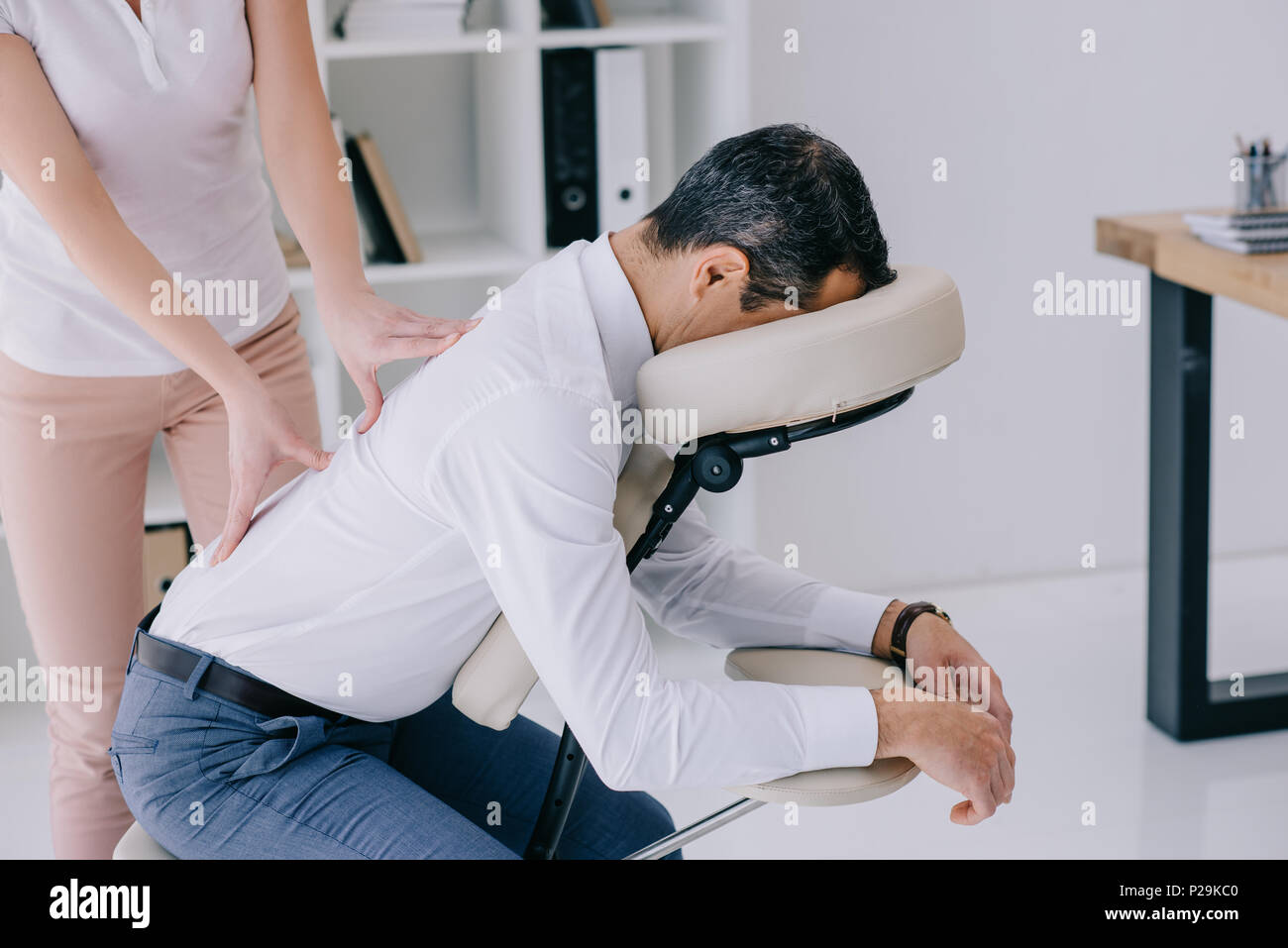 https://c8.alamy.com/comp/P29KC0/masseuse-doing-back-massage-on-seat-at-office-P29KC0.jpg
